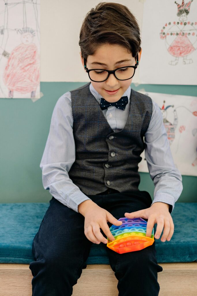 Genitore seduto accanto al figlio che stima: accogliere lo stimming senza interrompere aiuta la regolazione emotiva del bambino