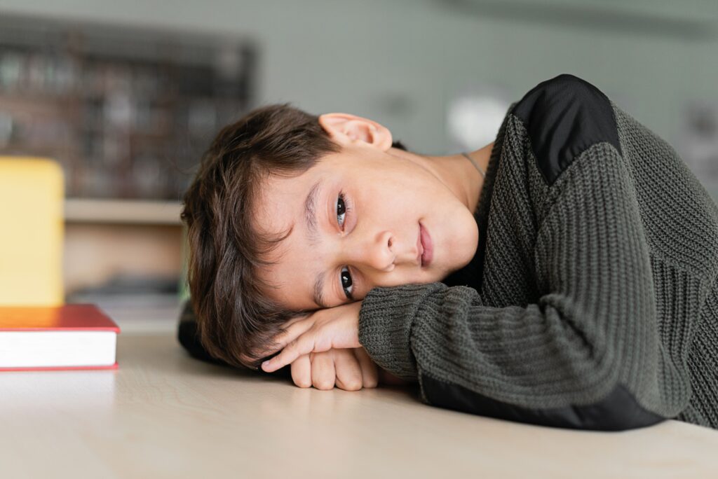 dsa cosa fare? bambino sconsolato riposa sulla scrivania con i libri di scuola